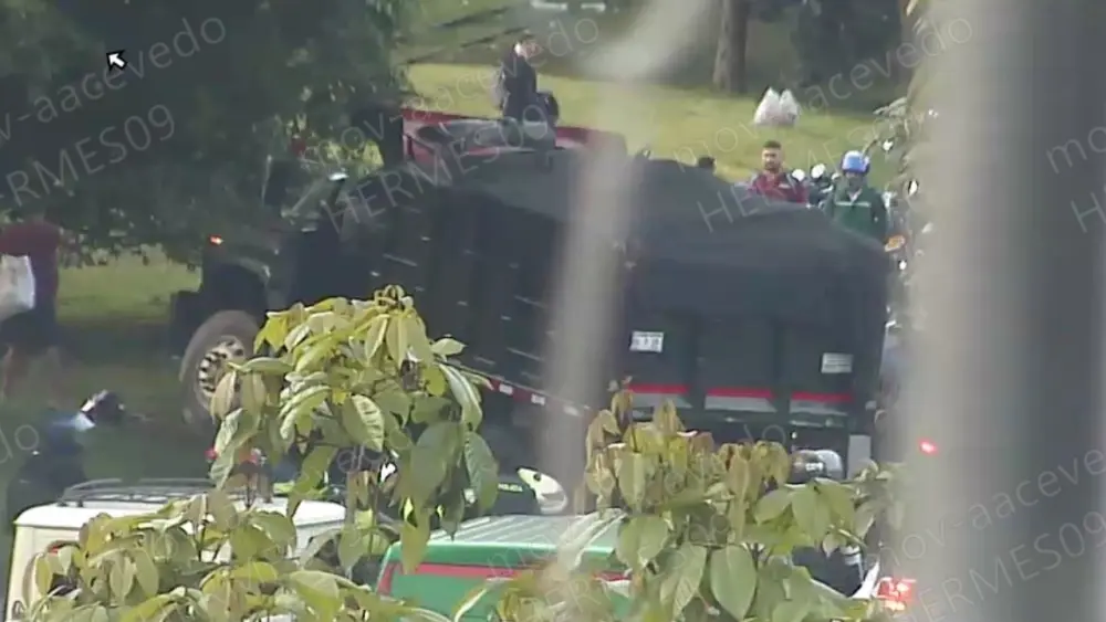 Volqueta accidentada en la avenida Regional de Medellín, con presencia de autoridades de tránsito y vehículos afectados.