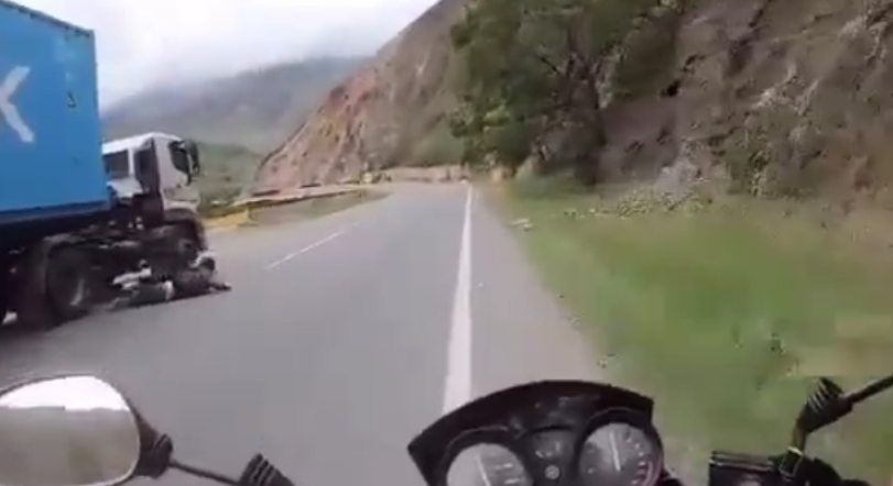 Momento en que un joven cae de una patineta a pocos centímetros de las llantas de una tractomula mientras circulaba por una vía de alto tráfico.