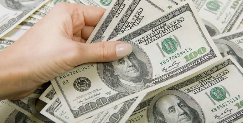Billetes de dólares y pesos colombianos representan la caída del precio del dólar.